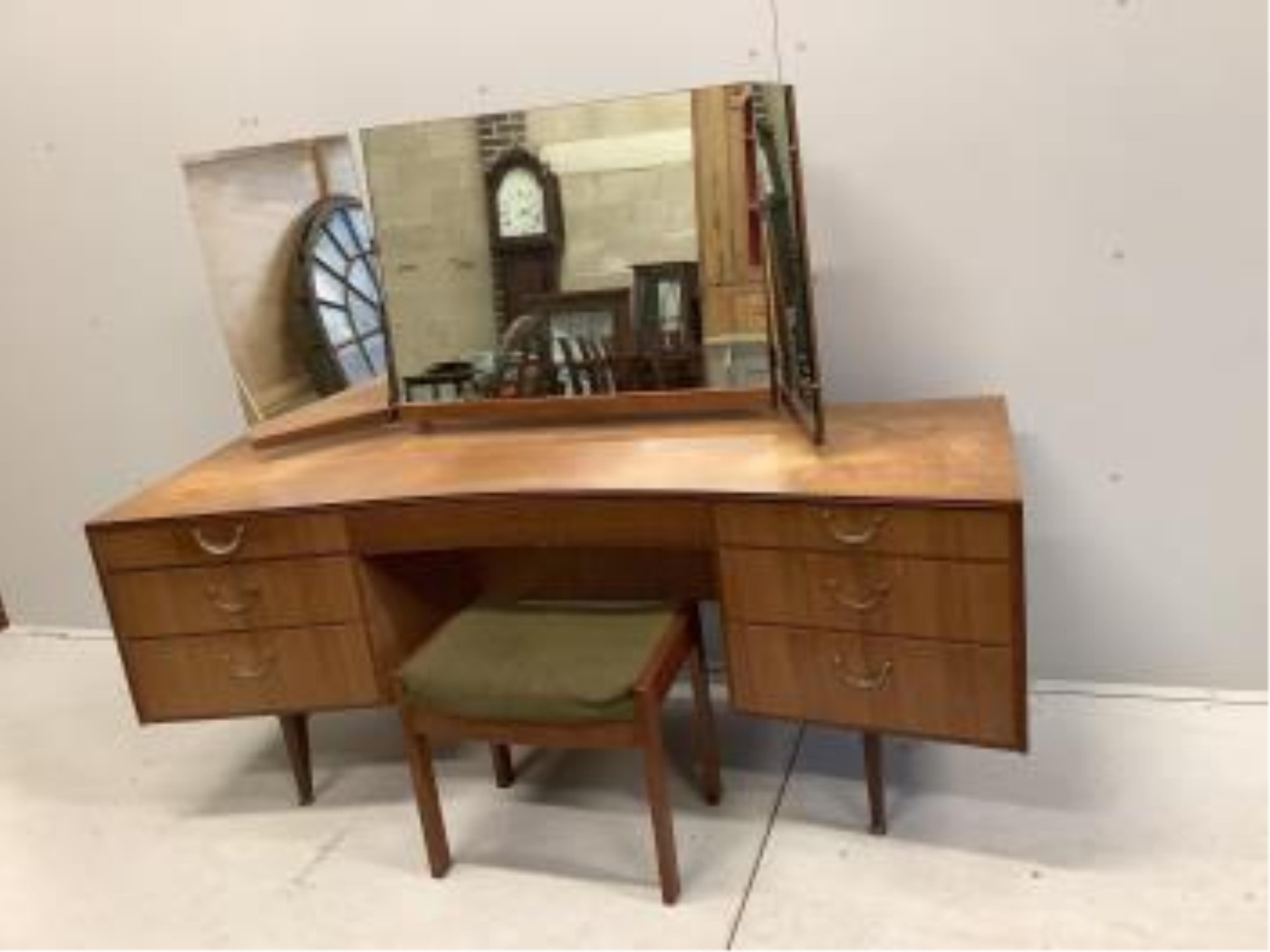 A mid century Meredew teak concave dressing table, width 162cm, depth 54cm, height 126cm, together with a stool and six drawer chest. Condition - poor to fair